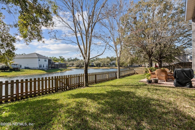 view of yard with a water view and a fenced backyard