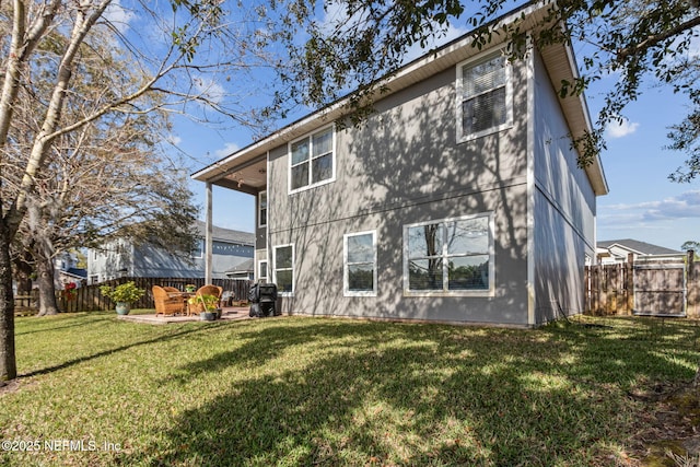 back of house with a patio, a lawn, and fence