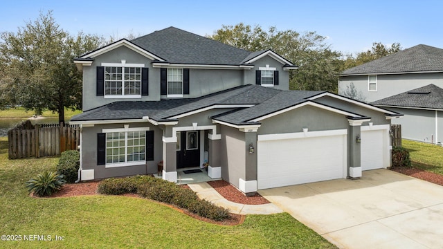 traditional home featuring a garage, fence, driveway, roof with shingles, and stucco siding