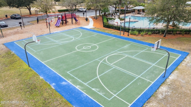 view of basketball court featuring community basketball court, playground community, and fence