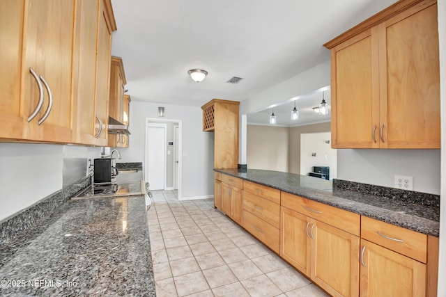 kitchen with light tile patterned floors, visible vents, baseboards, ventilation hood, and dark stone counters