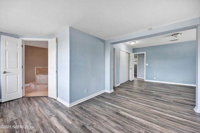 empty room featuring baseboards and wood finished floors