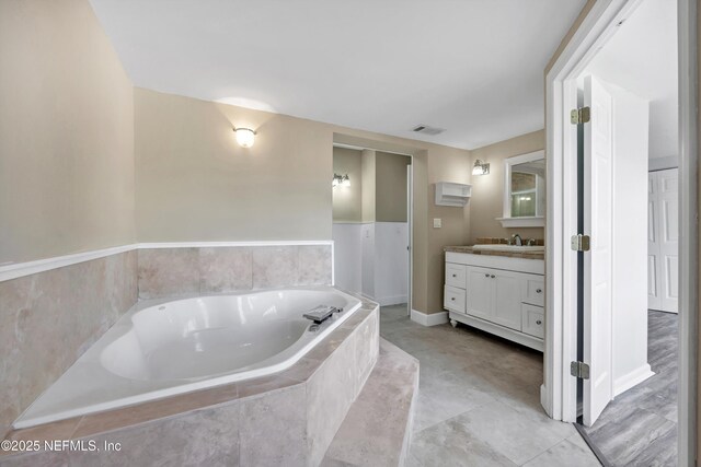 full bathroom with visible vents, a bath, and vanity