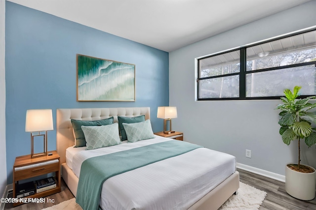 bedroom featuring baseboards and wood finished floors