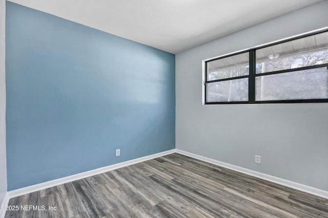 unfurnished room with wood finished floors and baseboards