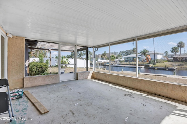 unfurnished sunroom with a water view