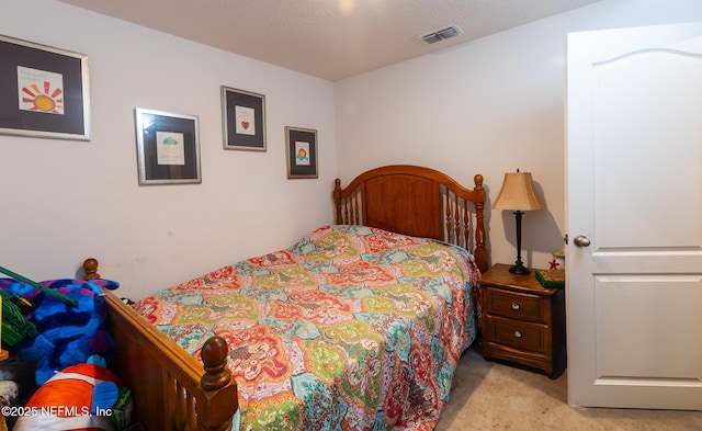 bedroom with a textured ceiling, carpet flooring, and visible vents