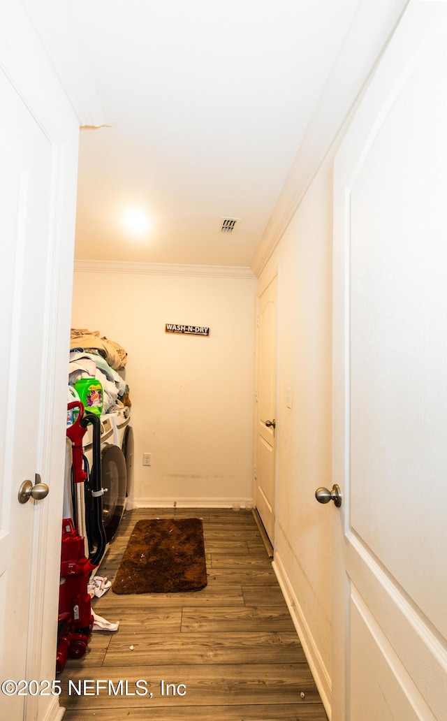 laundry room with laundry area, washer and clothes dryer, wood finished floors, and crown molding