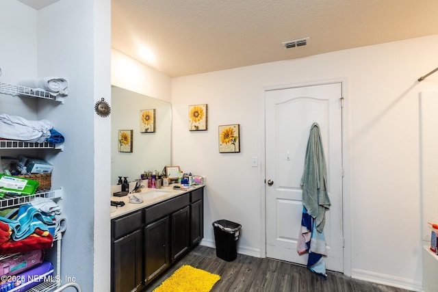 full bath with baseboards, visible vents, wood finished floors, and vanity