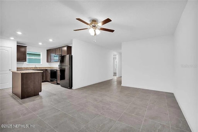 kitchen featuring dark brown cabinetry, a ceiling fan, electric stove, freestanding refrigerator, and stainless steel microwave