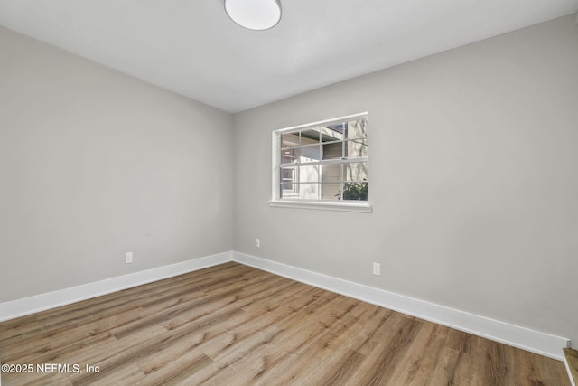 unfurnished room with baseboards and wood finished floors