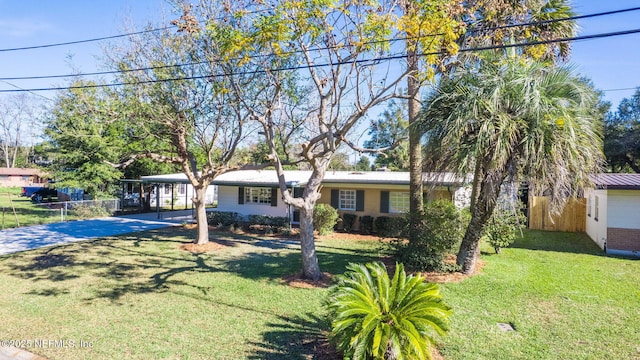 view of front of property featuring a carport, a front lawn, fence, and driveway