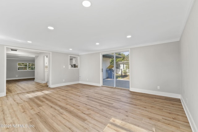 unfurnished room featuring ornamental molding, light wood-type flooring, a wealth of natural light, and visible vents