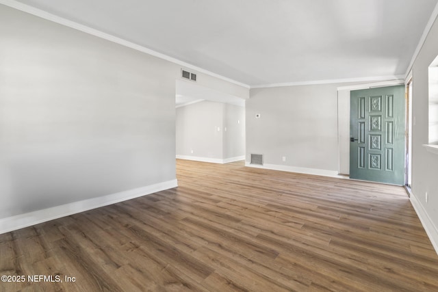 spare room with visible vents, baseboards, and wood finished floors