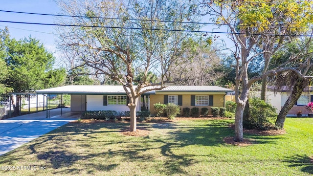 view of front facade featuring driveway, metal roof, a front lawn, a carport, and brick siding