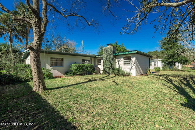 back of property featuring a lawn, a chimney, and fence