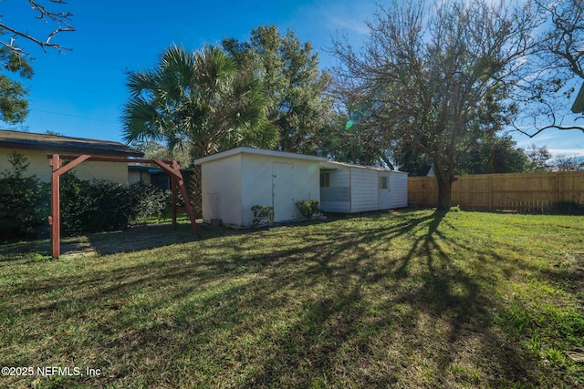 view of yard featuring an outdoor structure and fence