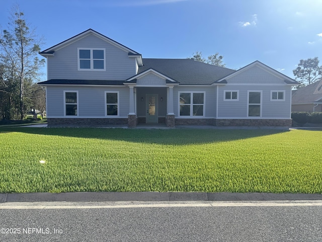 craftsman inspired home with stone siding and a front lawn