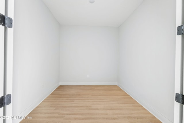 additional living space featuring baseboards and light wood finished floors