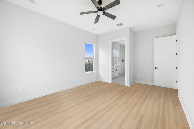 unfurnished bedroom with visible vents, light wood-style flooring, a ceiling fan, connected bathroom, and baseboards