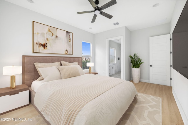 bedroom featuring light wood finished floors, visible vents, connected bathroom, ceiling fan, and baseboards