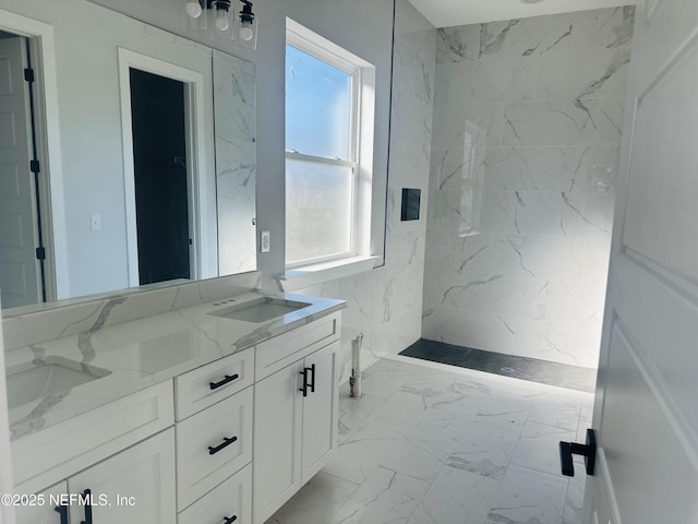 bathroom featuring double vanity, marble finish floor, a marble finish shower, and a sink