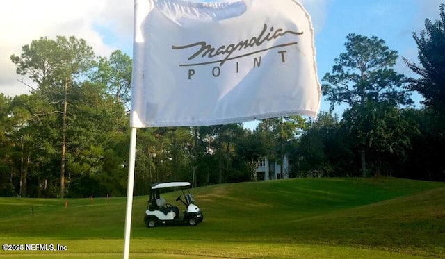 view of property's community featuring a yard and view of golf course
