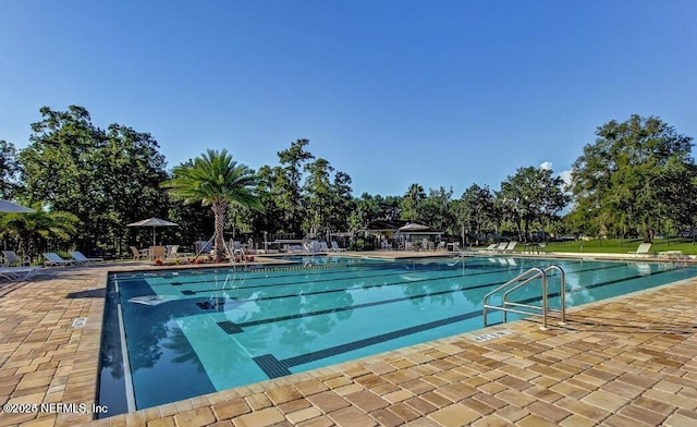 community pool with a patio and fence