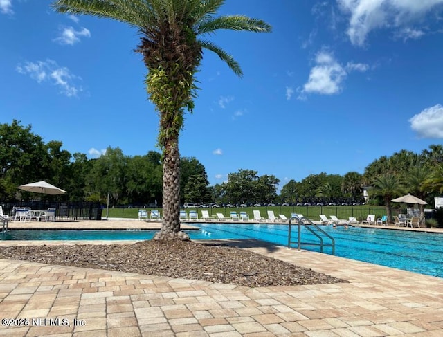 pool featuring fence and a patio