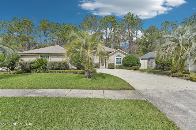 view of front of home with concrete driveway, a front lawn, and fence