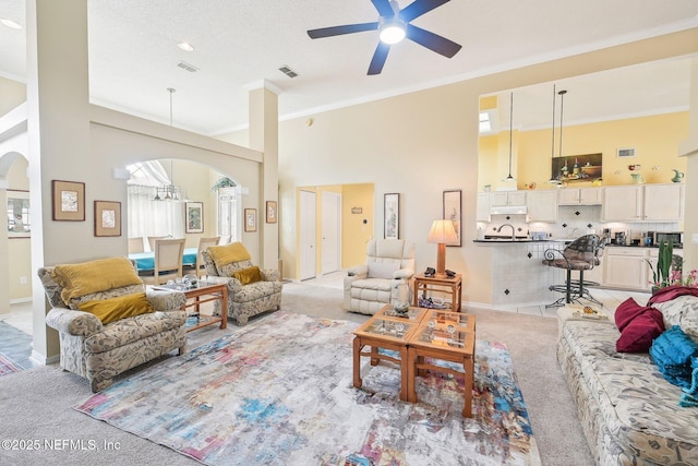 living room with visible vents, a towering ceiling, and light colored carpet