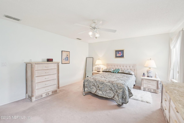 bedroom with a ceiling fan, light colored carpet, and visible vents