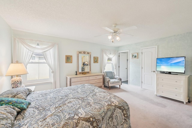 carpeted bedroom featuring a textured ceiling and a ceiling fan