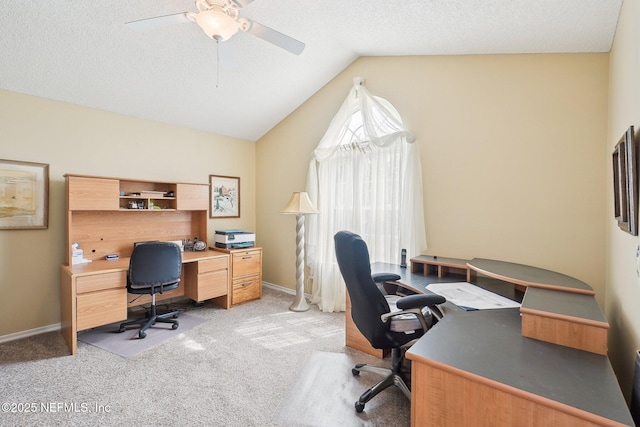 office area featuring lofted ceiling, a textured ceiling, baseboards, and light colored carpet