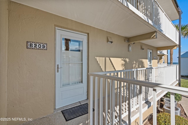 doorway to property with stucco siding and a balcony