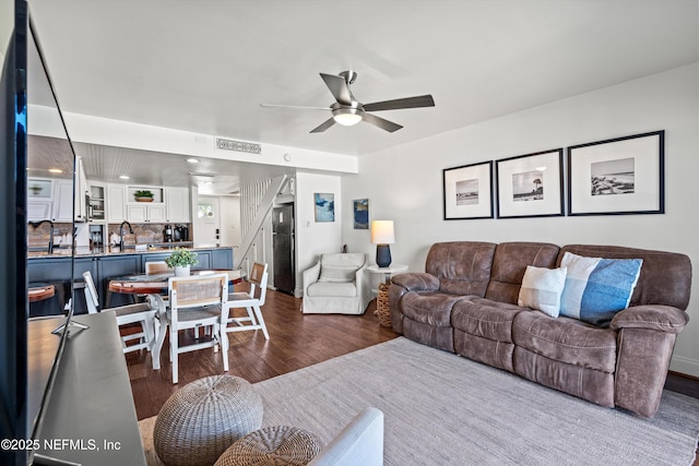 living area featuring ceiling fan and dark wood-style floors