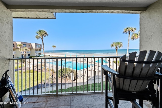 balcony featuring a beach view and a water view