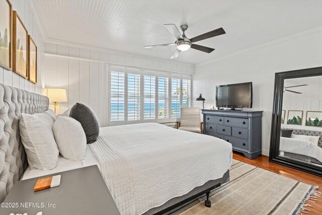 bedroom featuring crown molding, wood finished floors, and ceiling fan