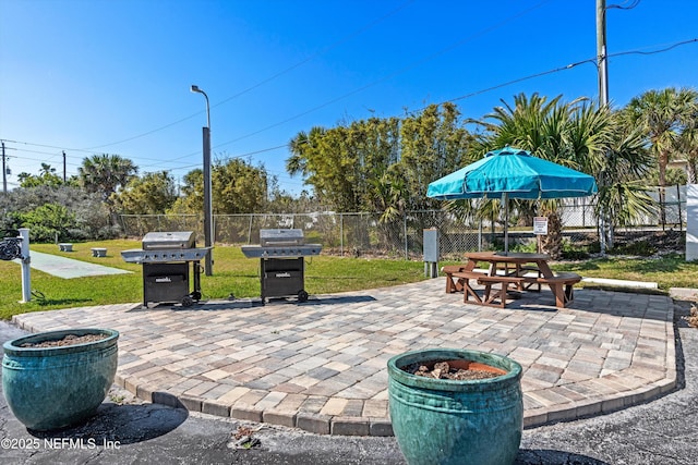 view of patio featuring outdoor dining space, a grill, and fence