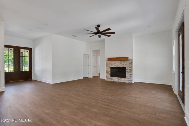 44024 Breezy Ln, Callahan, FL 32011 - unfurnished living room with dark wood-style flooring, french doors, ceiling fan, baseboards, and a fireplace