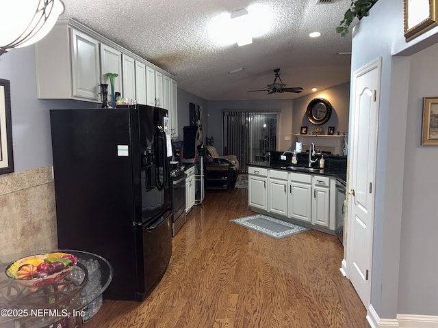 kitchen featuring gas range, wood finished floors, black refrigerator with ice dispenser, a textured ceiling, and a sink