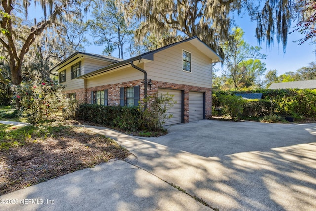 view of property exterior featuring brick siding, an attached garage, and driveway