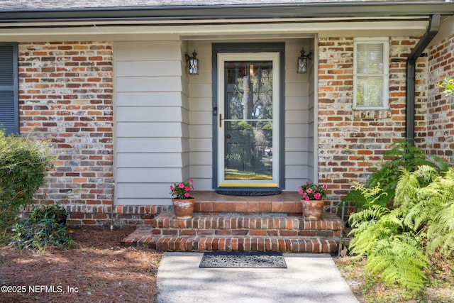 property entrance featuring brick siding and covered porch