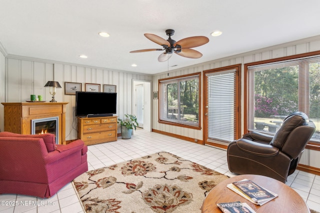 tiled living room with a glass covered fireplace, recessed lighting, and a ceiling fan