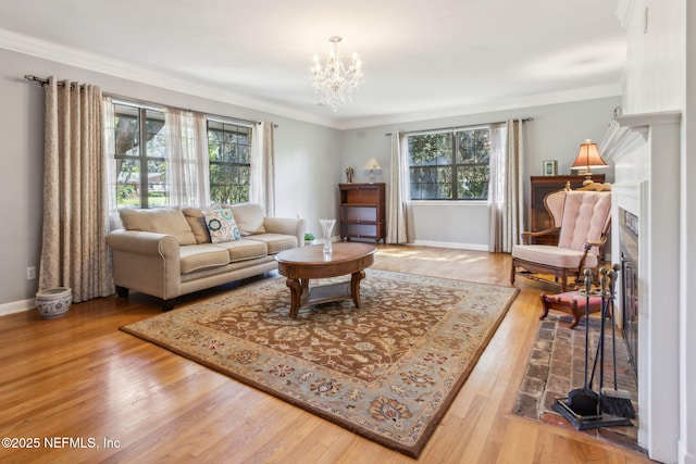 living room featuring a healthy amount of sunlight, ornamental molding, an inviting chandelier, and wood finished floors