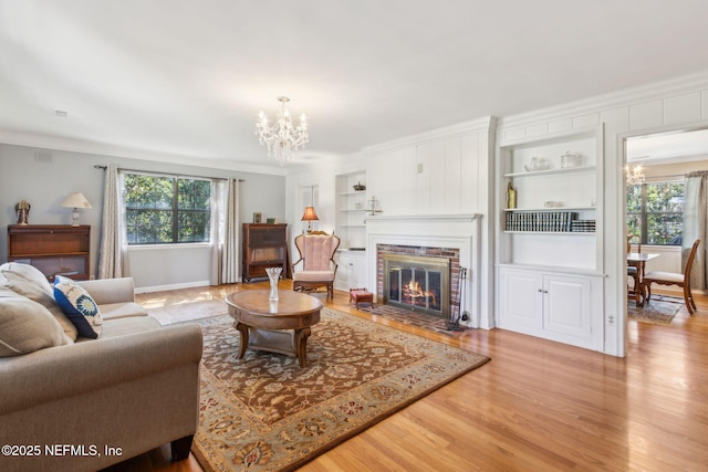 living area featuring crown molding, a healthy amount of sunlight, and a chandelier