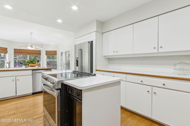 kitchen with light countertops, light wood-style flooring, a healthy amount of sunlight, and stainless steel appliances