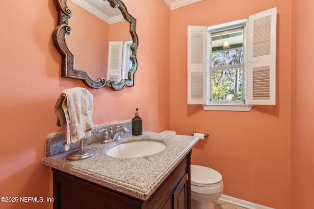 bathroom featuring vanity, crown molding, toilet, and baseboards