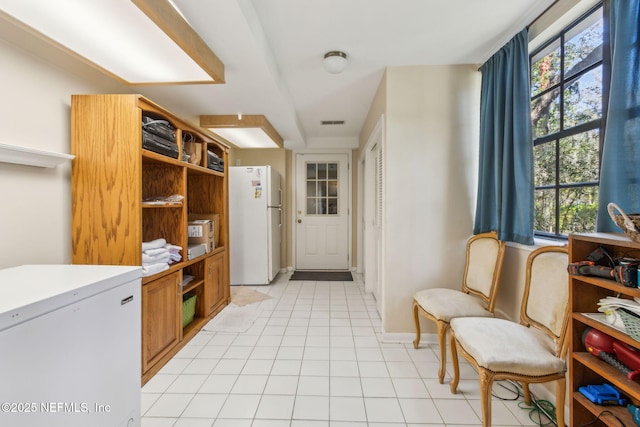 laundry area with light tile patterned floors, baseboards, and visible vents