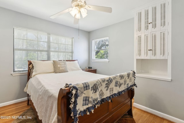 bedroom with ceiling fan, baseboards, and wood finished floors